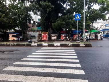 Bandung, Endonezya - 18 Mayıs 2025: Zebra geçişleri yayalar için kesişen yolun ortasındaki beyaz çizgilerdir. 