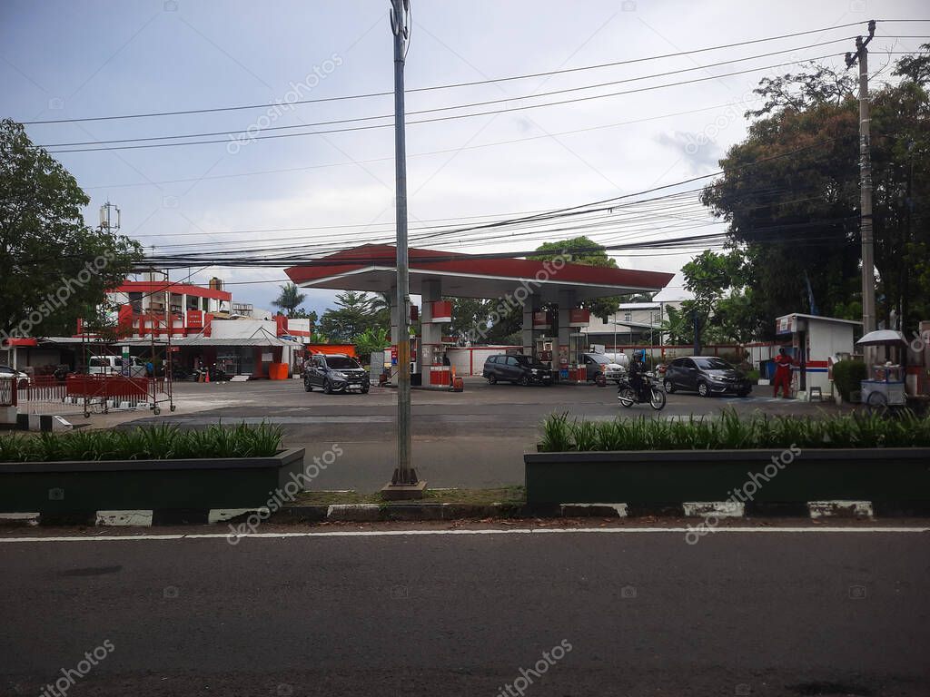 Bandung, indonesia - may 18, 2025 : Pertamina gas station across the street with several vehicles refueling