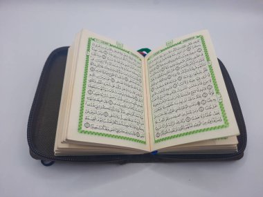 Beyaz arkaplan üzerinde bir cep Al-Quran sayfası resmi 
