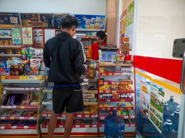 Bandung, Endonezya - 26 Mayıs 2025: Bir müşteri, bir minimarket masasında kasiyer tarafından servis ediliyor. 