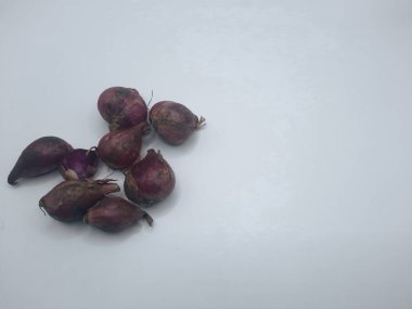 Beyaz arka planda birkaç karanfil kırmızı soğan. 