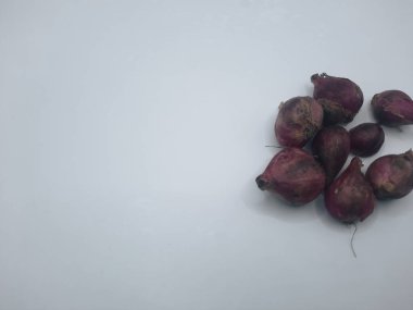 Beyaz arka planda birkaç karanfil kırmızı soğan. 