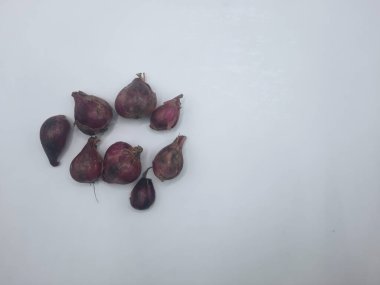 Beyaz arka planda birkaç karanfil kırmızı soğan. 