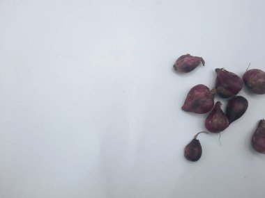 Beyaz arka planda birkaç karanfil kırmızı soğan. 