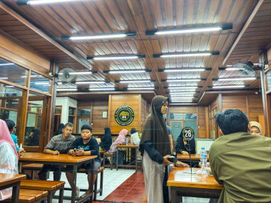 Bandung, Endonezya - 18 Haziran 2025: Kalabalık Bakso Saturnus gıda tezgahının içindeki atmosfer, çok sayıda insanın yemeklerini beğendiği görülebilir.