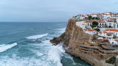 Portekiz 'deki güzel beyaz evlerin ve dalgaların hava manzarası.