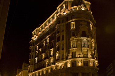 Süslü bina gece aydınlandı. Mimari detaylar, büyük ölçek ve tarih anlayışı..