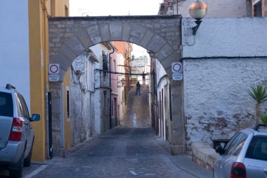 Dar bir caddede taş kemer iskeleti. Tarihi mimari, kasaba manzarası ve geçiş hissi..