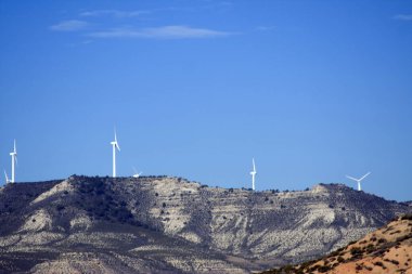 Wind turbines on a mountain range. Renewable energy, wind power, and a landscape with modern technology. clipart