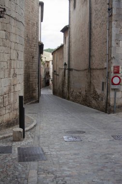 Eski binaların arasında sessiz bir kaldırım taşı caddesi var. Tarihi mekan, taş duvarlar ve sokak lambaları.