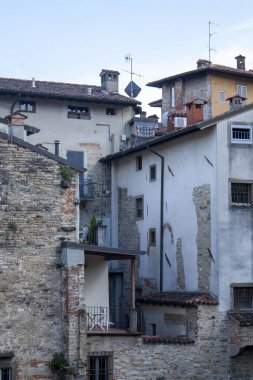 Eski binaların karışımlı şehir manzarası. Taş ve yıpranmış cepheler, balkonlar ve antenler