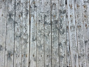 Kırsal bir tahta kaldırımın eskimiş ahşap kalasları çatlamış ve beyaz boya ve pas lekeleri soyulmuş..