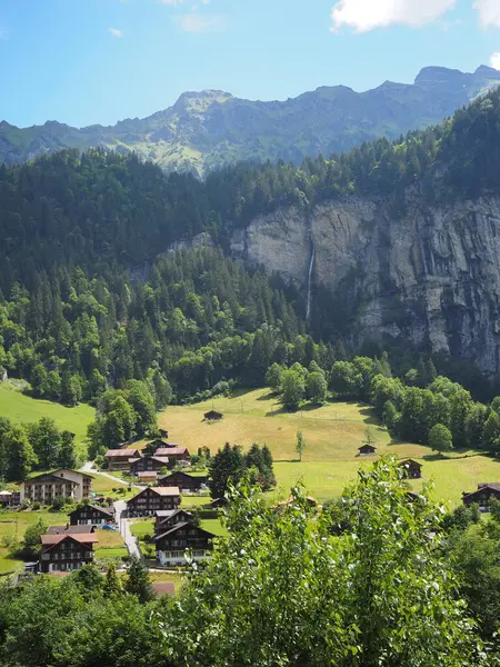 Şelalesi olan yeşil bir dağ köyü. Güneşli bir günde şelale vadisi. Lauterbrunnen, İsviçre. İsviçre Alpleri 'nin yeşil çayırları.