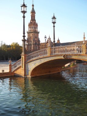 Plaza de Espana güneşli bir günde, Seville, Endülüs, İspanya. Kule, desenli köprü, fenerler ve nehir kanalı..