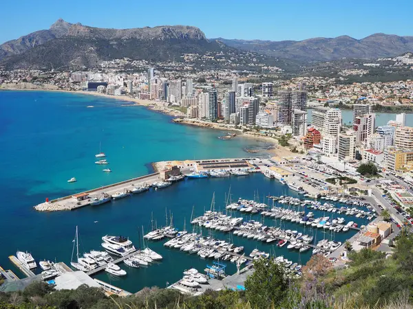 Calpe kıyılarının panoramik manzarası, Costa Blanca, Alicante bölgesi, İspanya. Kumsal boyunca gökdelenler, beyaz yatlı liman koyları, mavi Balearic Denizi ve güneşli bir günde dağlar. İspanya 'da tatiller.