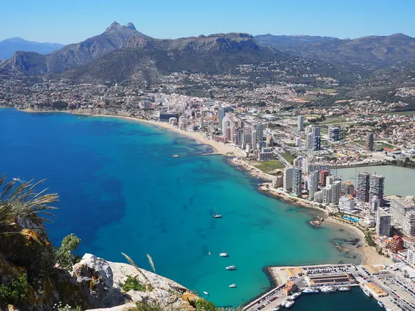 Calpe kıyılarının panoramik manzarası, Costa Blanca, Alicante bölgesi, İspanya. Kumsal boyunca gökdelenler, mavi Balear Denizi ve güneşli sıcak bir günde dağlar. İspanya 'da bir tatil köyünde tatil.
