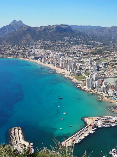 Calpe kıyılarının panoramik manzarası, Costa Blanca, Alicante bölgesi, İspanya. Sahil boyunca gökdelenler, liman, mavi Balear Denizi ve güneşli bir günde dağlar. İspanya 'da tatiller.