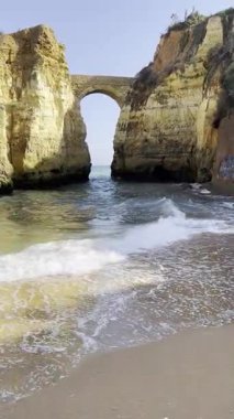 Algarve 'deki altın uçurumlar arasında taş kemer köprüsü. Mavi suyu ve dalgaları olan kumsal Lagos, Portekiz 'de. Pinhao Fort Köprüsü.