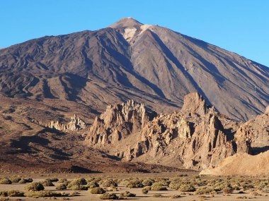 Gün batımında güneşli bir günde Teide yanardağının eteklerinde kurumuş bitkilerle taştan vadi. Roques de Garcia, Tenerife, Kanarya Adaları, İspanya.