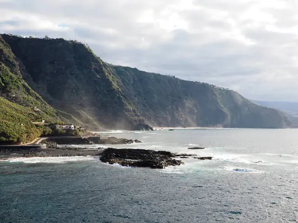 Güneş tarafından aydınlatılan volkanik kayalıklar Mesa del Mar 'dan gün batımında Atlantik Okyanusu kıyısında. Tenerife 'nin dramatik manzarası, Kanarya Adaları, İspanya.