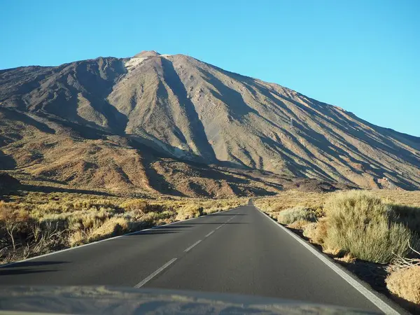 Gün batımında güneşli bir günde Teide yanardağının eteklerine kadar uzanan yol. Tenerife 'nin dramatik manzarası, Kanarya Adaları, İspanya.