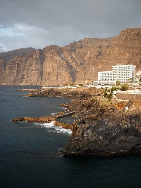 Günbatımında Los Gigantes kıyıları: güneşli uçurumlar, kayalık kıyılar, doğal havuz ve sakin mavi Atlantik Okyanusu. Tenerife, Kanarya Adaları, İspanya.