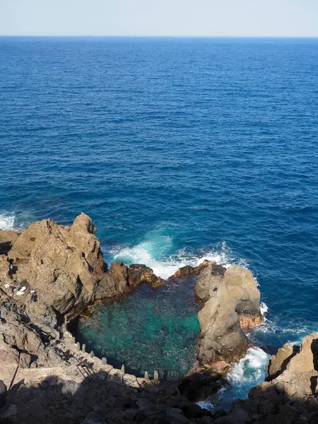 Doğal havuz Charco de la Laja, Tenerife 'deki Atlantik Okyanusu kıyısındaki siyah volkanik kayalarda berrak mavi sakin su. İspanya 'daki Kanarya Adaları' nda tatil ve turizm.
