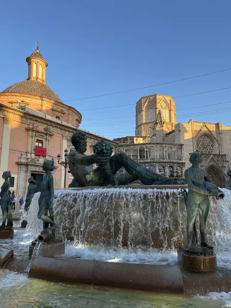 Fuente del Turia ile merkez meydanı, Valencia, İspanya 'nın tarihi merkezinde Turia Fontaine. Plaza de la Virgen 'de güneşli bir günde mavi gökyüzüne karşı Avrupa Gotik Valencia Katedrali