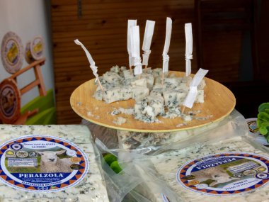 OVIEDO, İspanya - 10 Mayıs 2024: Oviedo, İspanya 'da Yükseliş Günü' nde ahşap çubuklarla Peralzola mavi koyun peyniri degutionu. La Peral peynirli süt ürünleri.