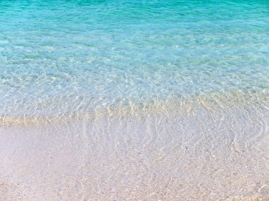 Kristal berrak turkuaz deniz suyu estetik arka planı. Cennet adası. Kumsal dalgalarla yıkanıyor. Yaz tatili hayalleri kurar. 