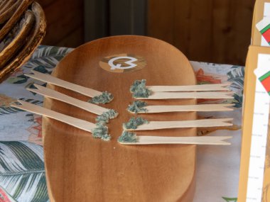 OVIEDO, SPAIN - MAY 10, 2024: Cabrales raw milk blue mould cheese on the wooden sticks on the Fair of Ascension Day in Oviedo,Asturias,Spain. Queso de Cabrales or quesu Cabrales.  clipart