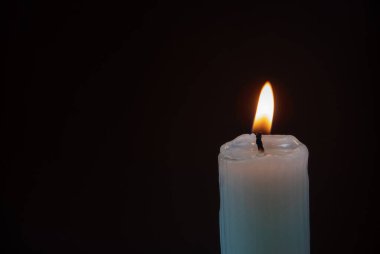 Koyu arkaplanda, fotokopi aletiyle tırtıklı mum yakmak. Karanlıkta parlak bir alev. Mum ışığı..