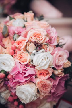 Canlı bir çiçek buketinin içine yerleştirilmiş gümüş bir nişan yüzüğü. Aşk, romantizm ve evliliğin sembolik bir görüntüsü. Düğün ve yıldönümü temaları için mükemmel..