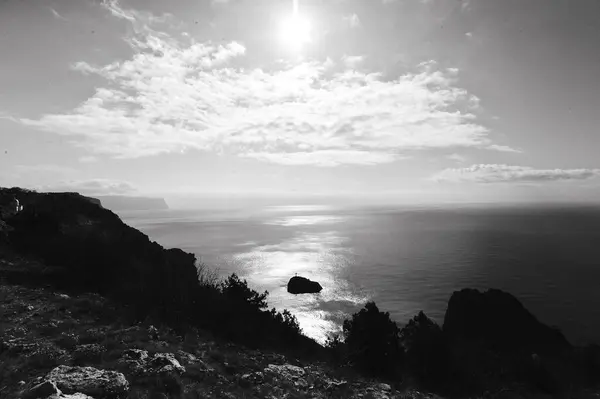 Dağlardaki güzel denizin siyah beyaz fotoğrafı.