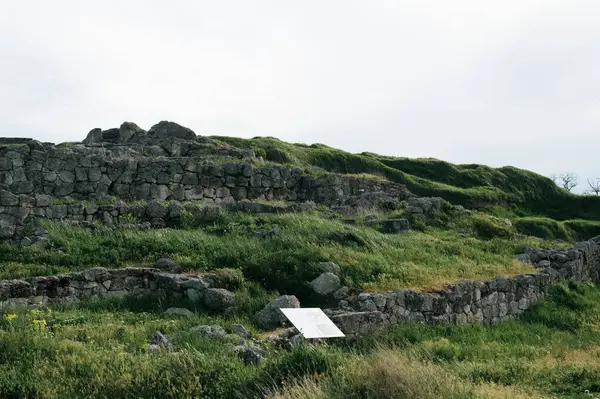 Yeşil çimlerde taş bir anıt.
