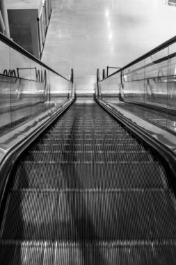 Havaalanında modern yürüyen merdiven, siyah ve beyaz.