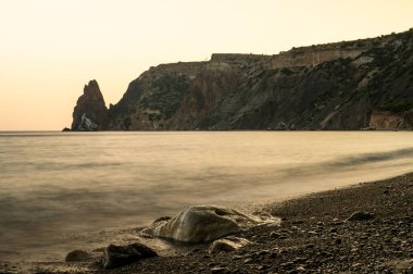 Gün batımında kayalık plajlı güzel bir deniz manzarası