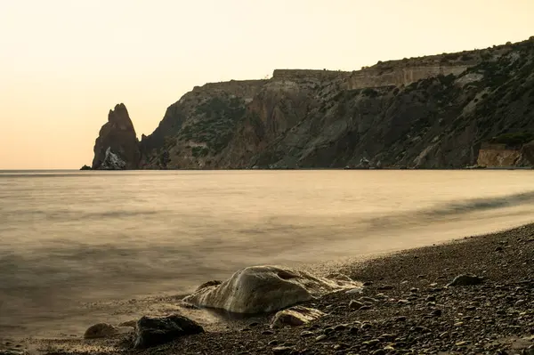 Gün batımında kayalık plajlı güzel bir deniz manzarası