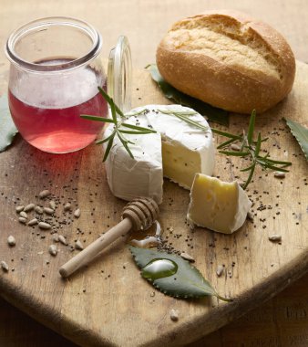 Bu natürmort fotoğrafta yumuşak, kremsi peynirli Camembert veya Brieplace 'in ahşap bir kesim tahtasında yer aldığı davetkar bir köy manzarası görülüyor. T