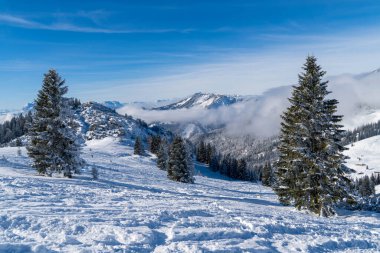 Alplerde kış yürüyüşü: Karla kaplı tepelerde ve doğanın her adımında güzelliğinin parladığı sakin manzaralarda nefes kesici bir yolculuk