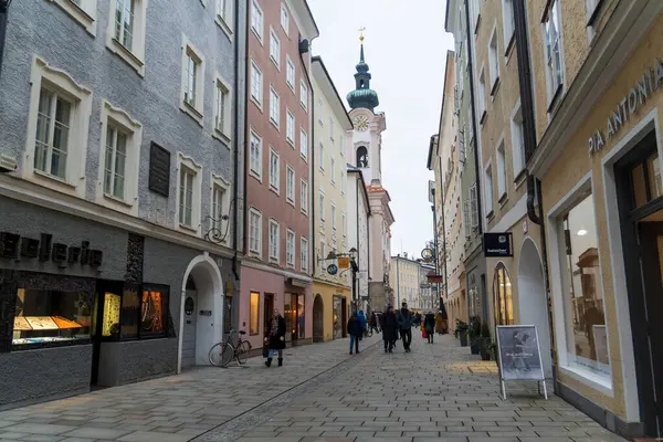 Salzburg 'da kış yürüyüşü, kaldırım taşı sokaklar, büyüleyici eski binalar ve kar ve tarihten oluşan bir battaniyeye sarılmış yüksek kale..