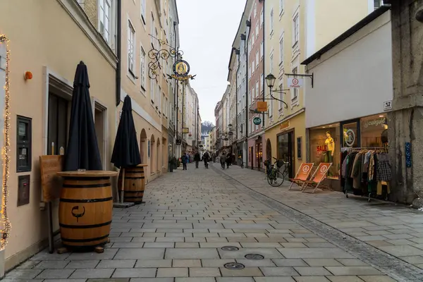 Salzburg 'da kış yürüyüşü, kaldırım taşı sokaklar, büyüleyici eski binalar ve kar ve tarihten oluşan bir battaniyeye sarılmış yüksek kale..
