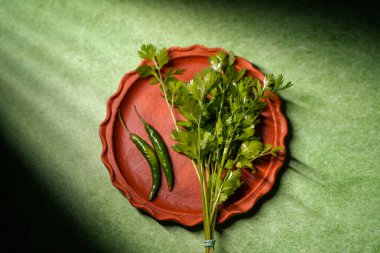 Kişniş yaprakları ve yeşil biberler toprakta saklanır..