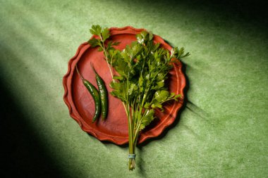 Kişniş yaprakları ve yeşil biberler toprakta saklanır..