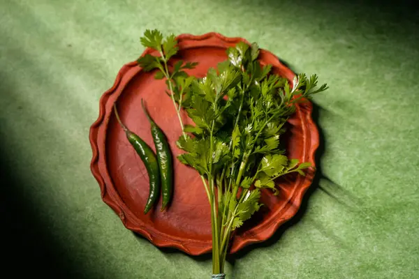 Kişniş yaprakları ve yeşil biberler toprakta saklanır..