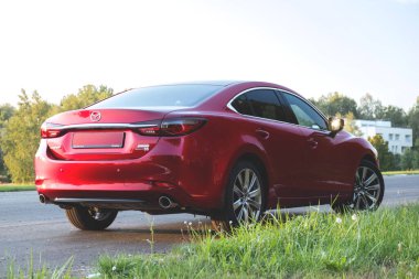 Brest, Belarus - 08 27 2019: Mazda 6 (GL) gün batımında boş yolda, arka planda ağaçlar.