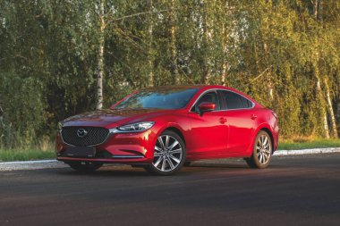 Brest, Belarus - 08 27 2019: Mazda 6 (GL) gün batımında boş yolda, arka planda ağaçlar.