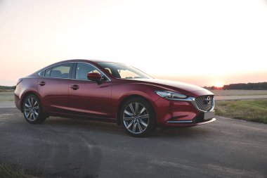 Brest, Belarus - 08 27 2019: Mazda 6 (GL) gün batımında boş yolda, arka planda ağaçlar.