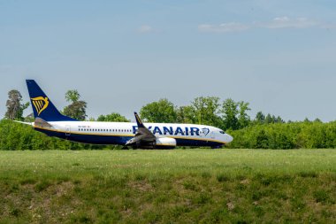 Lublin, Polonya - 05 03 03 2024: Ryanair Boeing 737-800 Ağaçlar ve yeşil alan yakınlarındaki bir pistte.