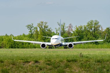 Lublin, Polonya - 05 03 03 2024: Ryanair Boeing 737-800 Ağaçlar ve yeşil alan yakınlarındaki bir pistte.